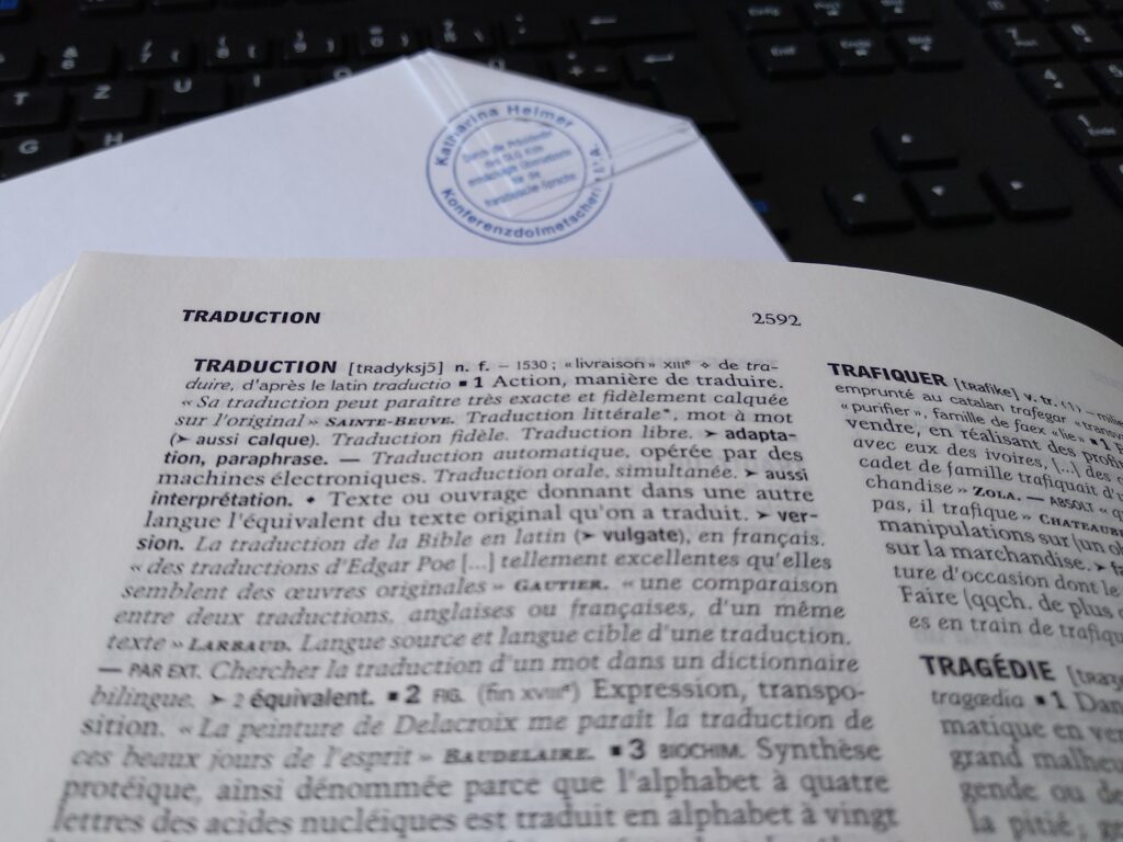 Das Bild zeigt einen Stempel und einen Auszug aus einem Wörterbuch